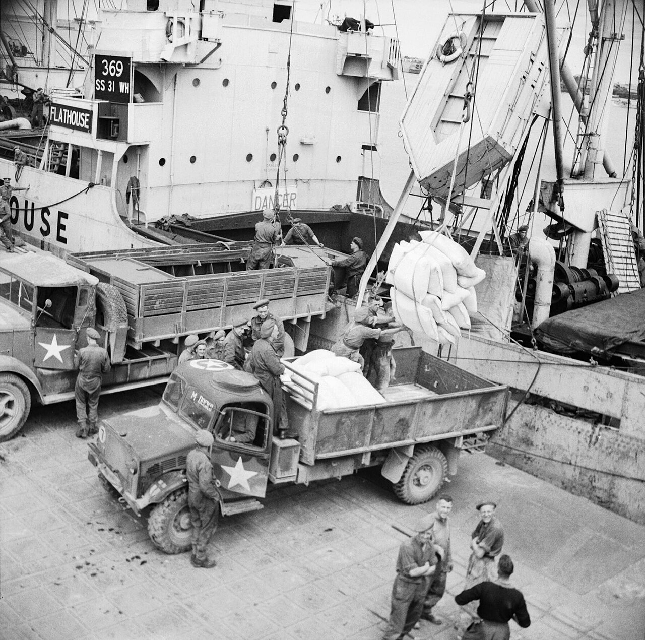 Supplies being unloaded from a ship at the Mulberry artificial harbour at Arromanches in Normandy, July 1944