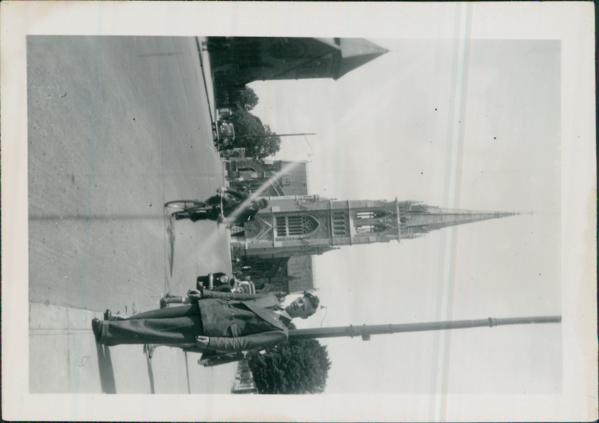 Charles Cable Savage on a motorcycle in front of a continental Gothic cathedral