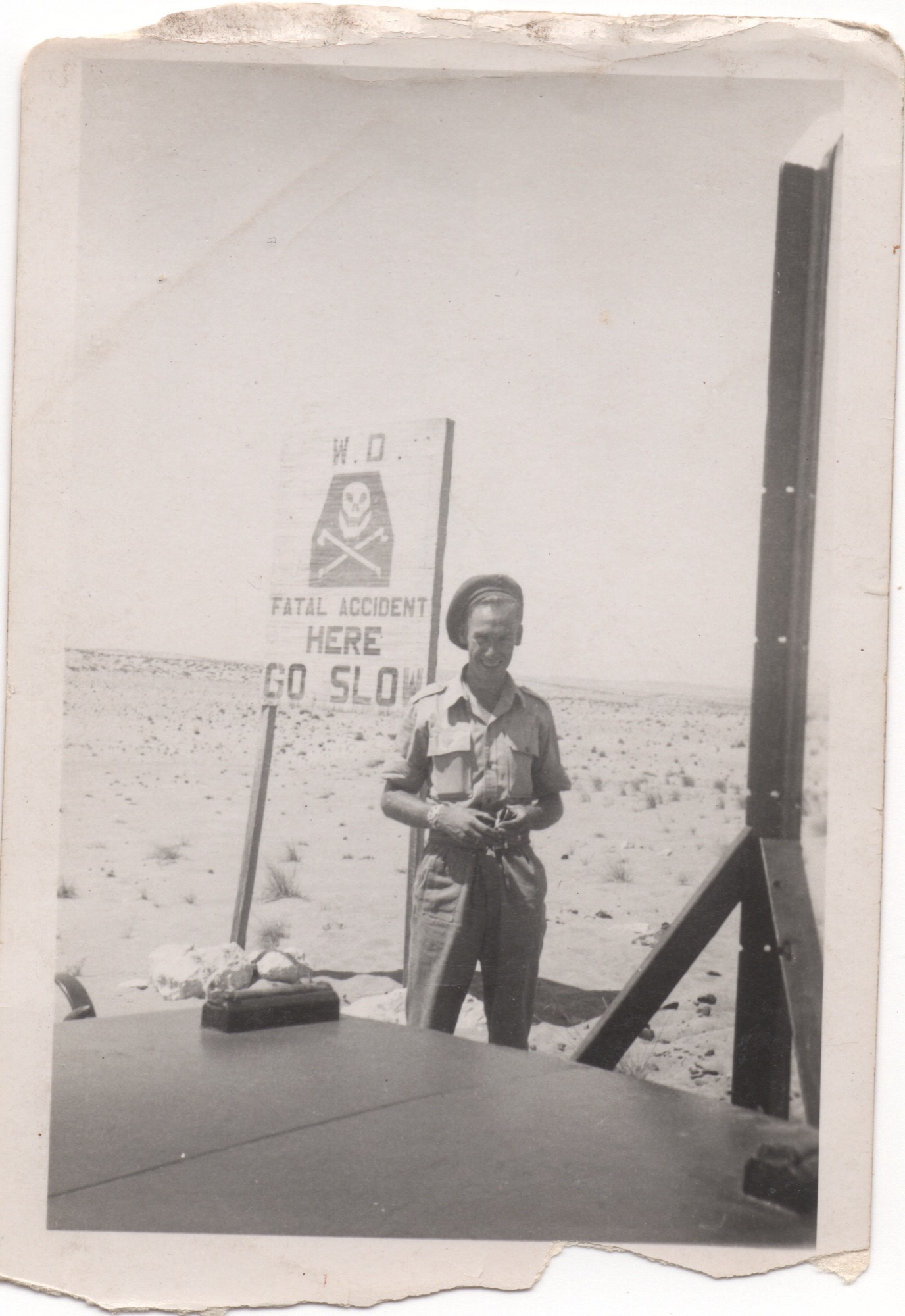 Charles next to a War Department fatal accident sign in the Egyptian desert
